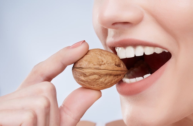 Thường xuyên cắn nhai vật cứng là nguyên nhân làm răng thật bị yếu đi