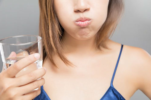 Súc miệng bằng nước muối giúp làm dịu triệu chứng đau ê ở răng