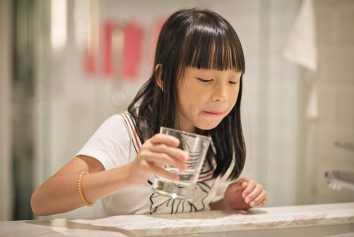 Cho trẻ súc miệng với nước muối để giảm đau răng đáng kể